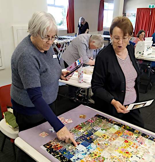 Alison and Roseanne discussing how to arrange the squares for best effect