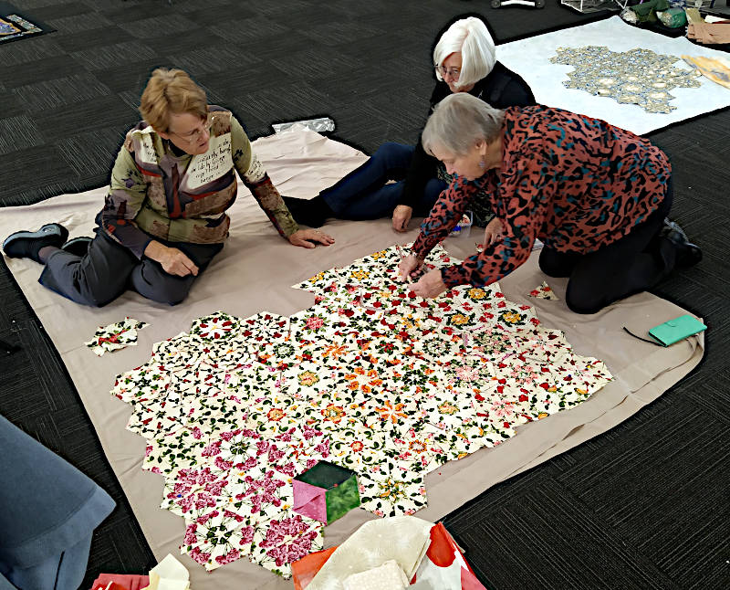 Rosalie, Eileen and Roseanne planning where to put the individual blocks for best effect