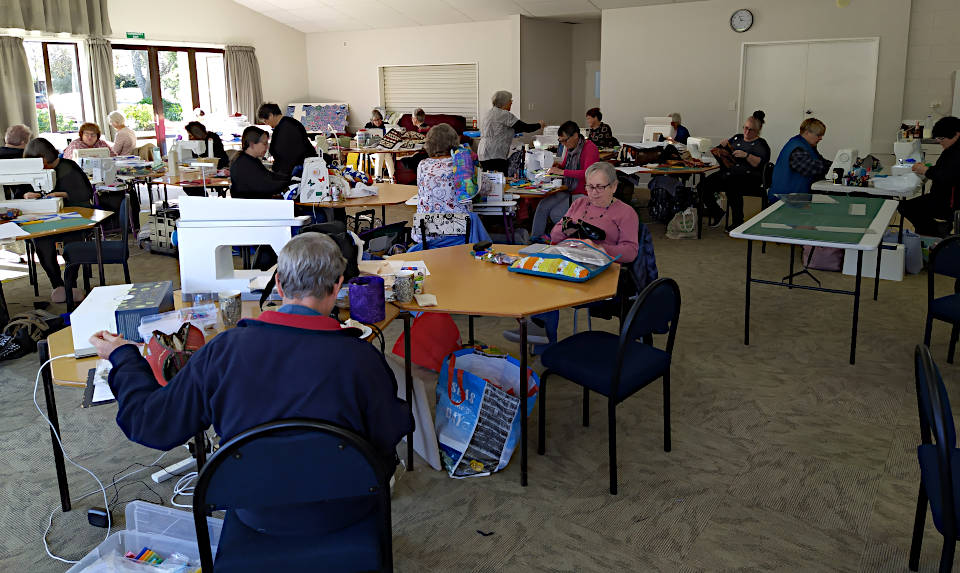 A wide shot of the quilting room showing everyone busy